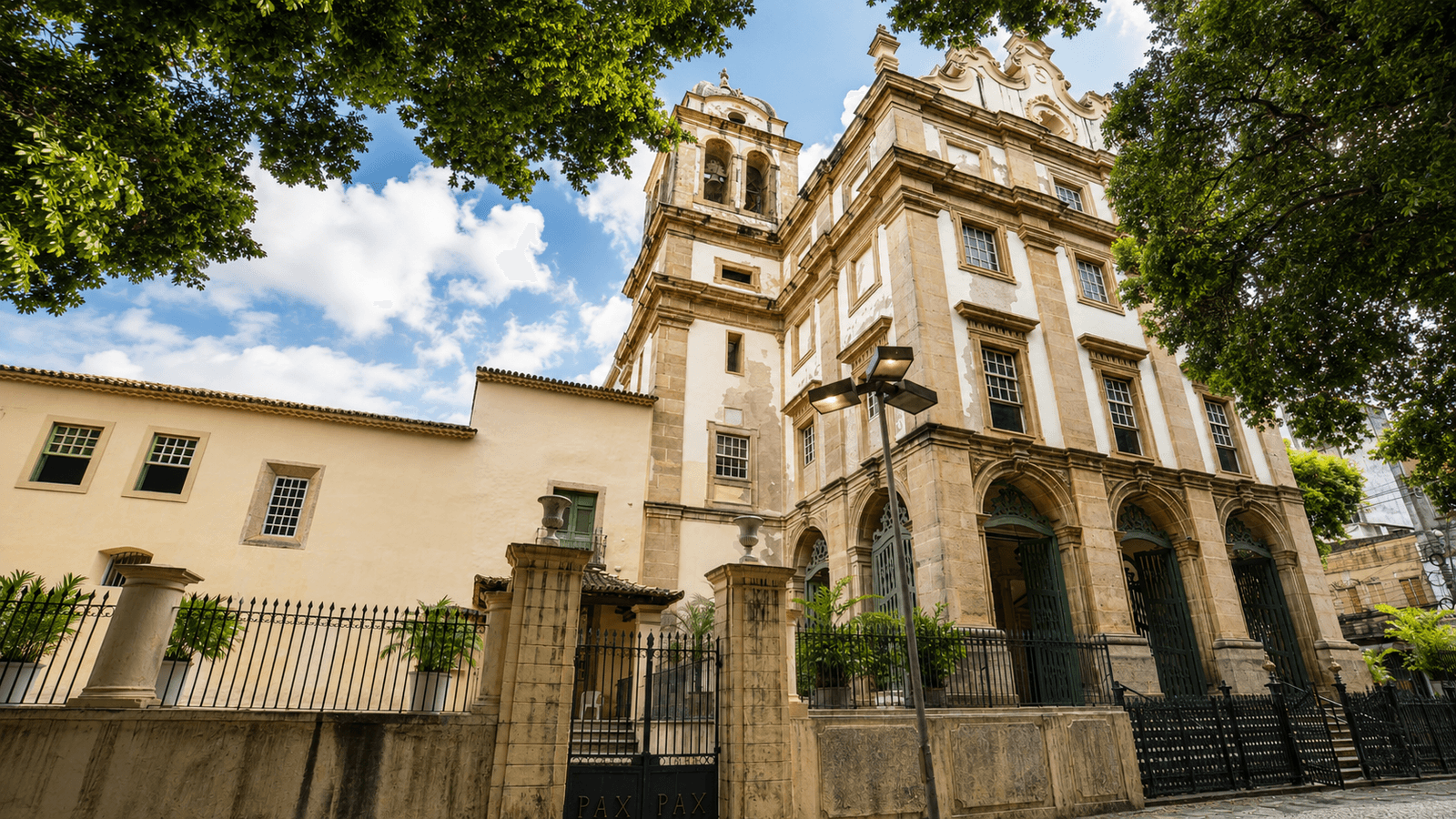 La fachada del Monasterio de São Bento de Salvador, enmarcada por árboles maduros.