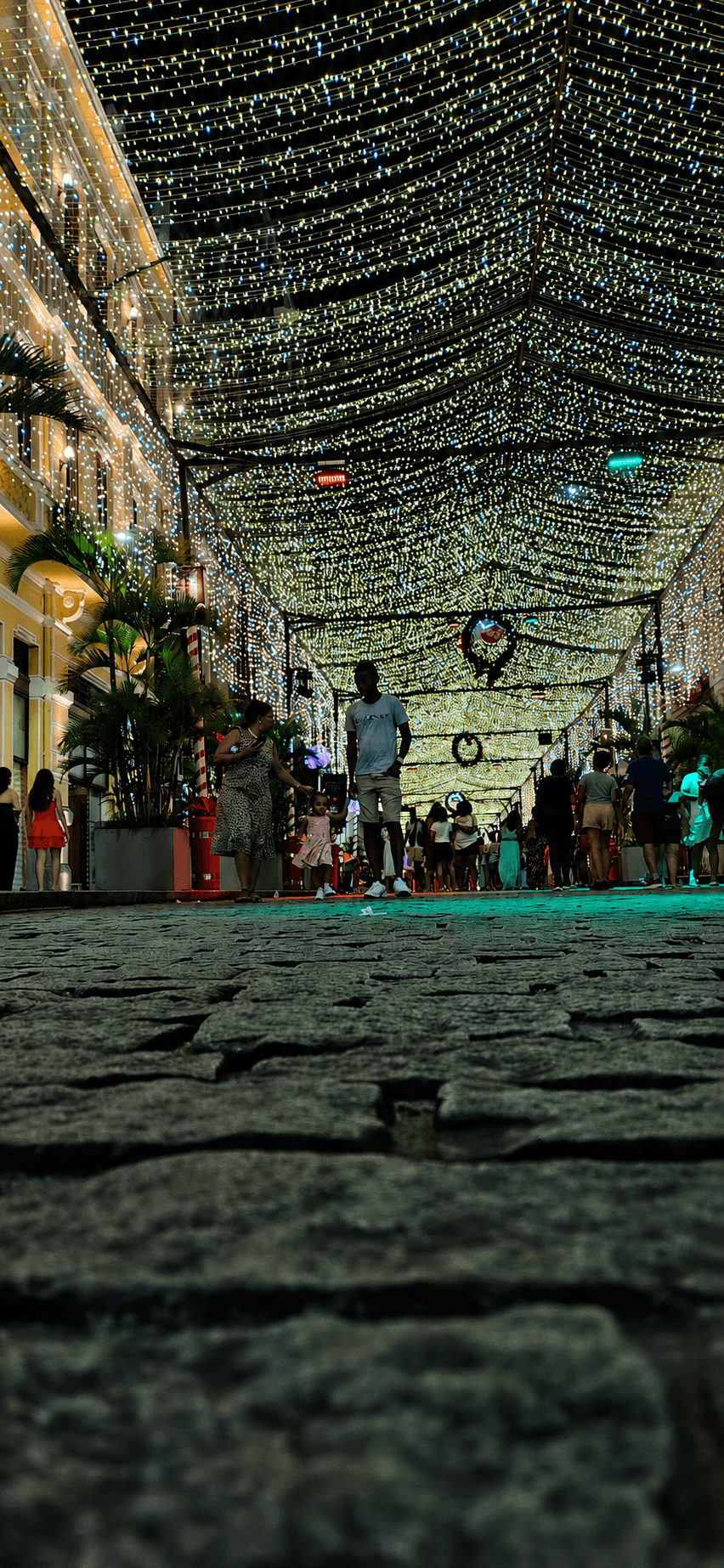 Rua Chile de noche bajo una densa iluminacion navidena, con personas caminando por la calle historica.