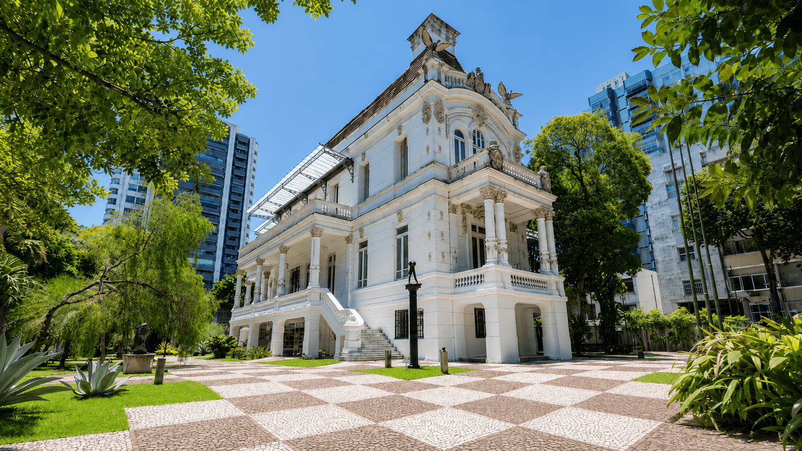 Palacete das Artes in Salvador, a white historic mansion framed by trees and landscaped gardens.
