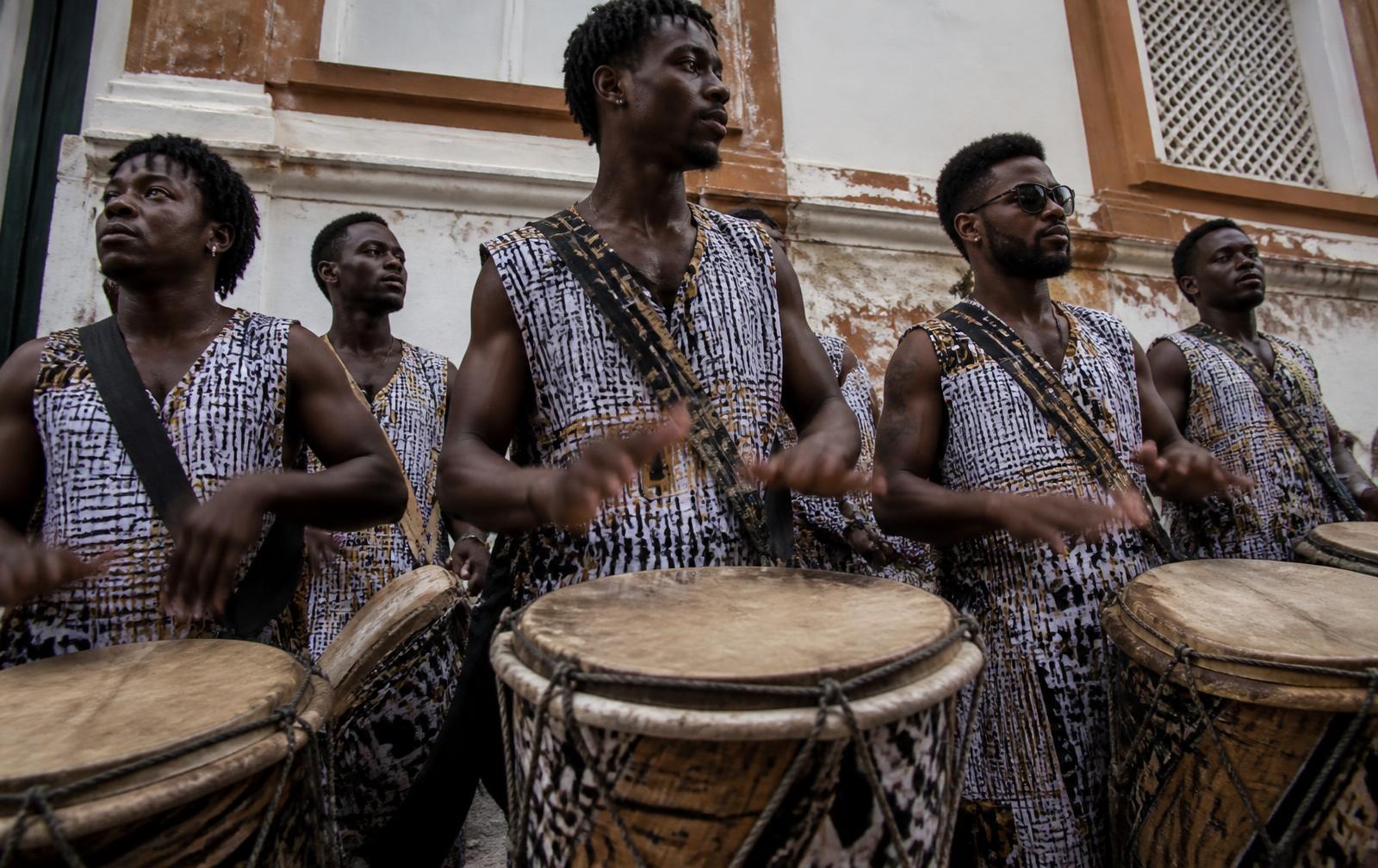 Percussionists of a bloco afro playing drums in front of a colonial wall in Salvador.