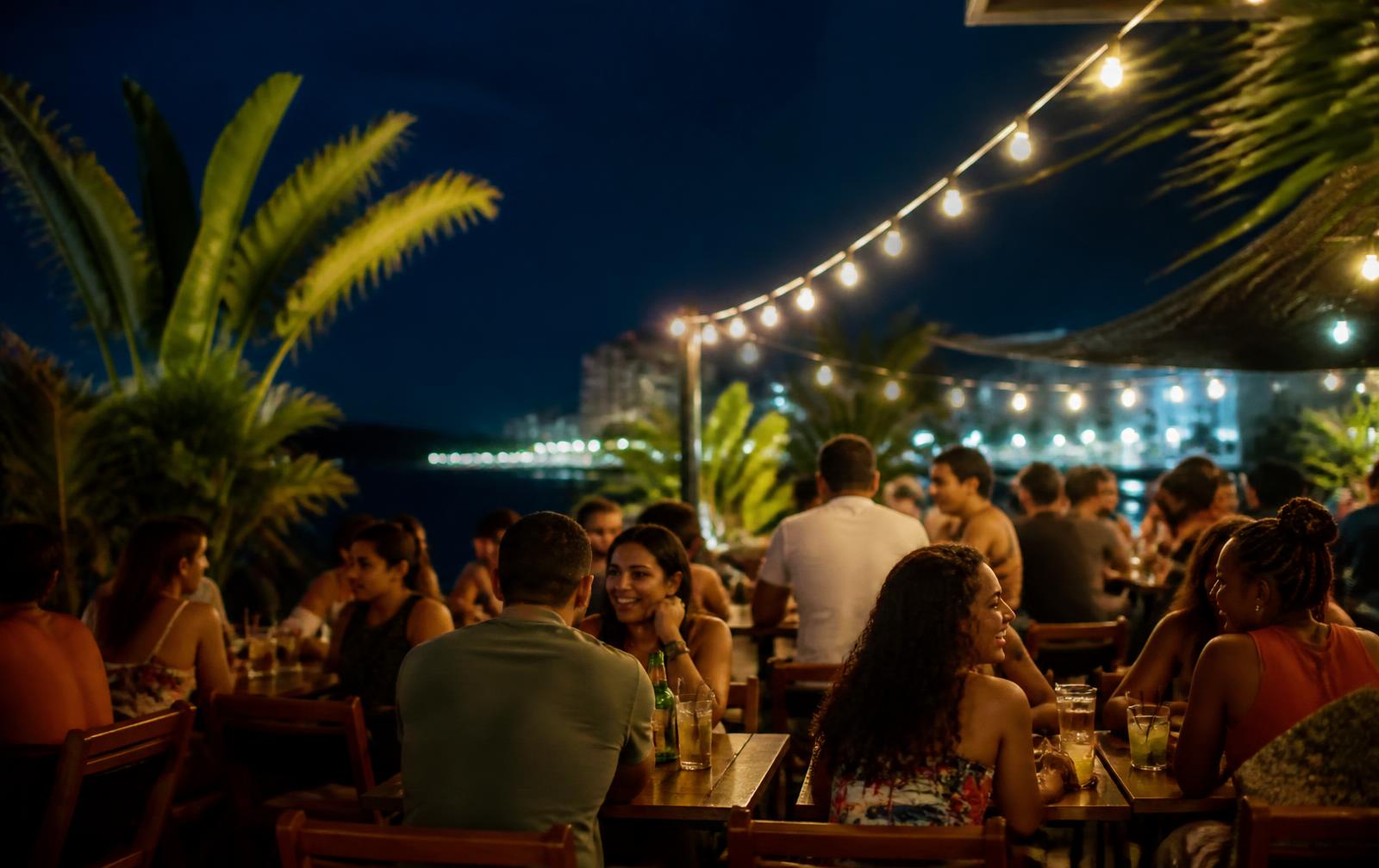 People at outdoor tables under string lights on a warm night in Rio Vermelho.